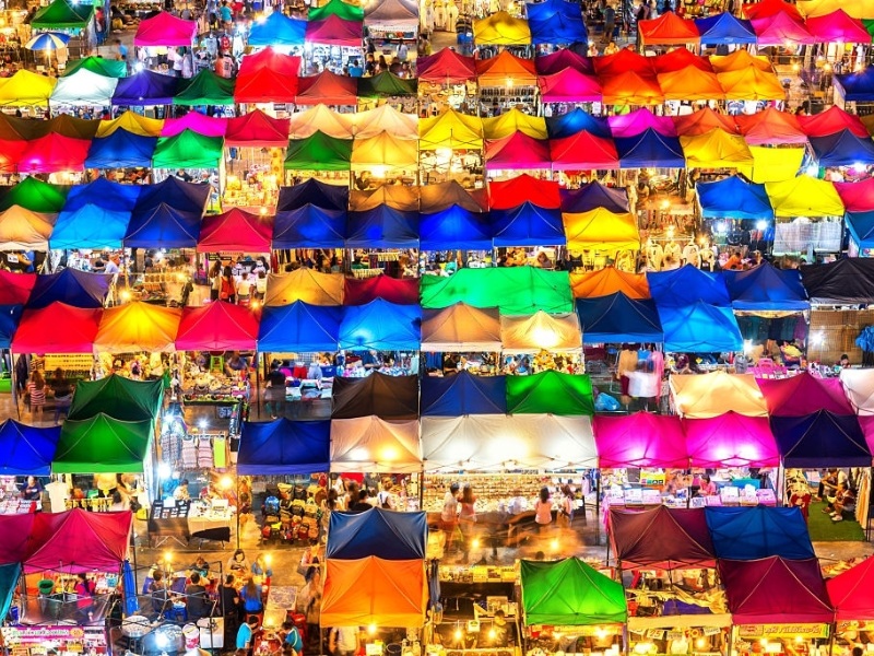 A sparkling aerial view of the night market, glowing with rows of vibrant stalls
